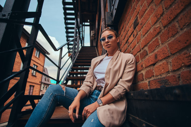 低角度照片厚脸皮的女人在后院戴墨镜和牛仔布。图片下载