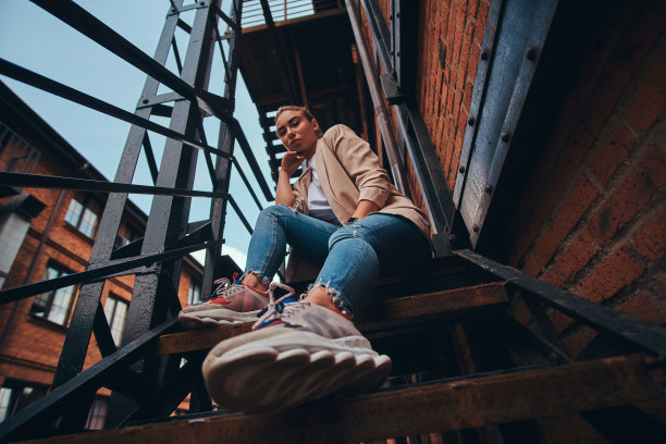 低角度照片厚脸皮的女人在后院戴墨镜和牛仔布。图片下载