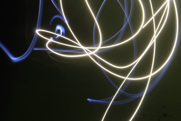 在长时间曝光的黑/绿背景照片上抽象彩色不规则线条。光绘摄影。用于叠加的不规则图案的灯光图片下载