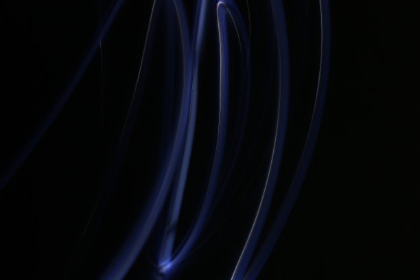 在长时间曝光的黑/绿背景照片上抽象彩色不规则线条。光绘摄影。用于叠加的不规则图案的灯光图片下载