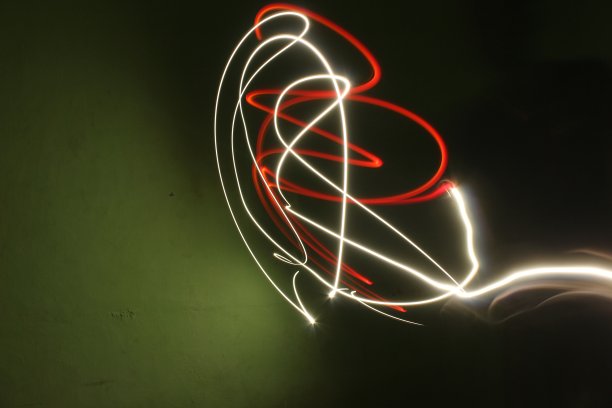 在长时间曝光的黑/绿背景照片上抽象彩色不规则线条。光绘摄影。用于叠加的不规则图案的灯光图片下载