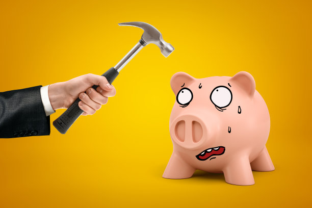 男性手握锤子在黄色背景上粉红色卡通脸储蓄罐图片下载