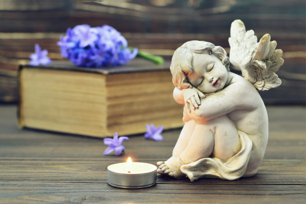 天使，燃烧的蜡烛和书中的风信子花图片下载
