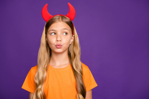 照片漂亮的小女士头带角在头上看空送飞吻同班男生万圣节派对穿橙色t恤孤立的紫色背景图片下载