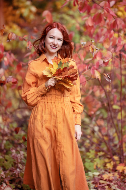一个有着古铜色头发的聪明女孩。自然美丽的秋天。图片下载