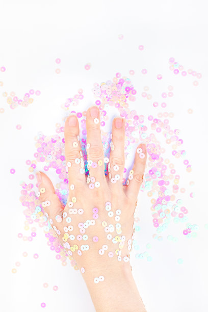 珍珠彩色纸屑点缀着女人的手图片下载