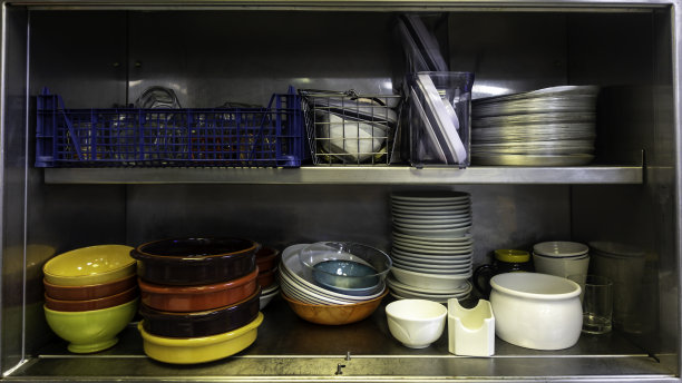 厨房用具堆放在一个不锈钢橱柜里图片下载