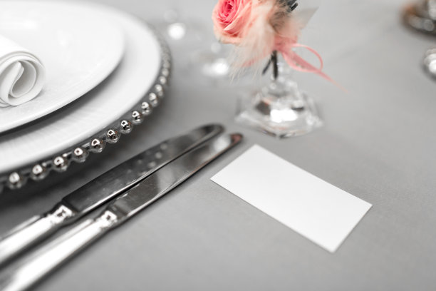 部分时髦的餐桌设置与盘子和餐具。旁边放着一张白色的名片。本空间图片下载