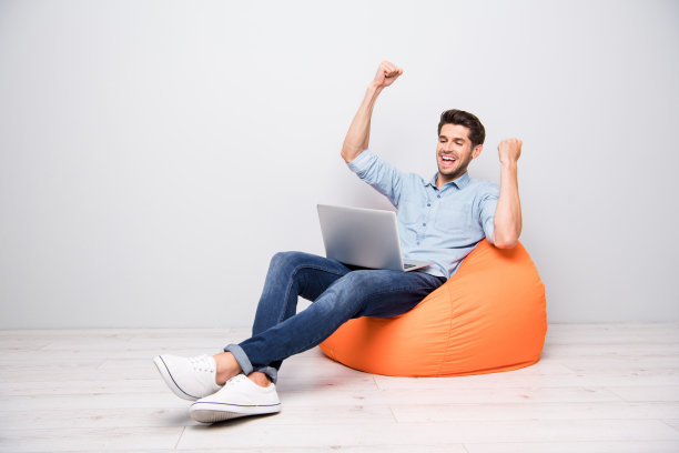 完整的身体尺寸转身的照片，愉快的积极的nice有吸引力的男人坐着，高兴地获得了新的信息孤立的灰色背景图片下载