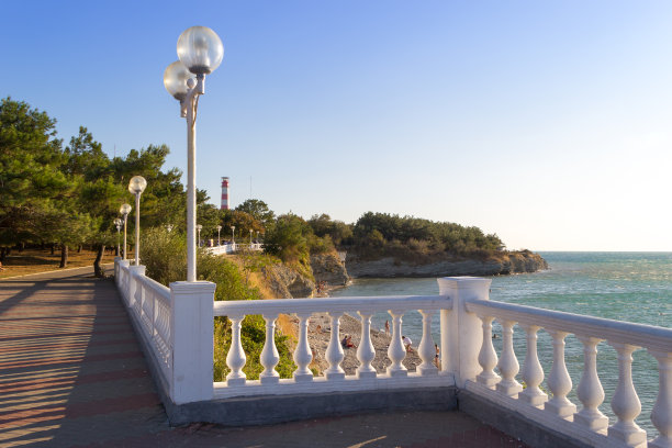 在俄罗斯格连兹克度假期间的一个阳光明媚的日子。沿着栏杆的围栏散步的美丽景色。背景是绿树和蓝天。图片下载