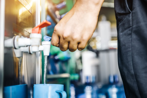 工人在工厂车间压水机的饮水机头图片下载