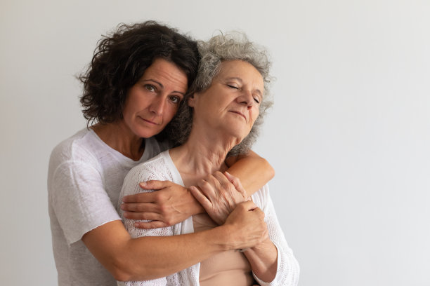 严肃的成年女儿在工作室里拥抱年长的母亲图片下载