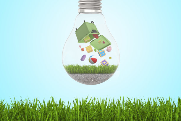 在绿色草地和蓝天的背景下，字母玩具积木和球从绿色垃圾桶里掉出来的灯泡图片下载