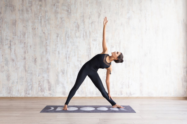 年轻迷人的女子练习瑜伽和伸展身体。素材图片