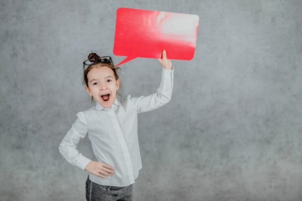可爱的宝贝体贴的女孩，双手呈红色矩形。灰色的背景。图片下载