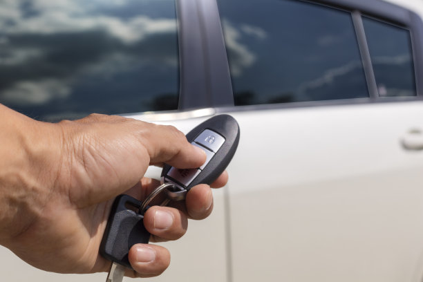 手动手握按钮解锁汽车遥控打开车门白色汽车。图片下载