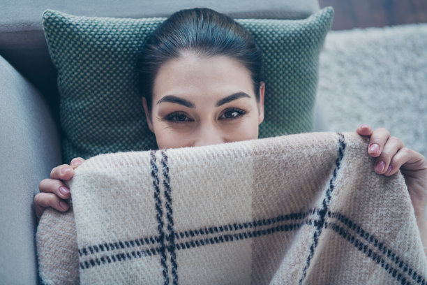 高角度照片漂亮有趣的女士躺在沙发上用毯子盖脸狡猾看男朋友有最好的早上在家图片下载