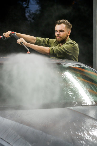 在洗车室外用加压水手动洗车。夏天洗车。图片下载