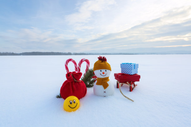 圣诞组成。红麻袋雪人，雪橇上的彩色礼品盒，条纹心形糖果和微笑表情符号。2020年新年快乐。图片下载