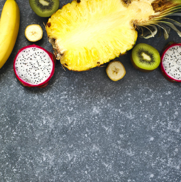 各种各样的异国水果在灰色的石头背景与复制空间图片下载