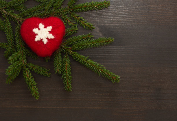 圣诞节的背景。红色的心和白色的雪花在深色的木头背景和云杉的树枝。圣诞文本框架。前视图。副本的空间。图片下载
