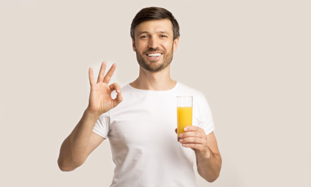 正面男人拿着橙汁杯，手势OK，白色背景图片下载