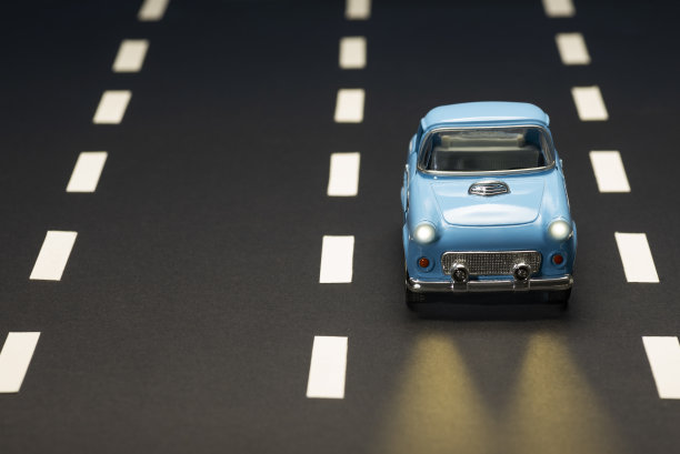 前视图的蓝色玩具汽车在道路上与道路的车道。图片下载