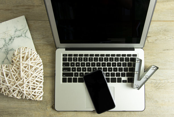 平铺木质书桌，电脑键盘，智能手机和螺旋笔记本。俯视图现代办公室工作场所。业务图片下载