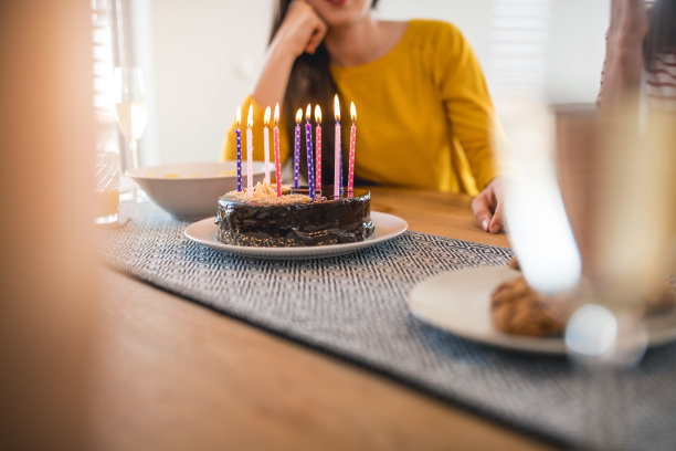 餐桌上拿着生日蛋糕的年轻女人图片下载
