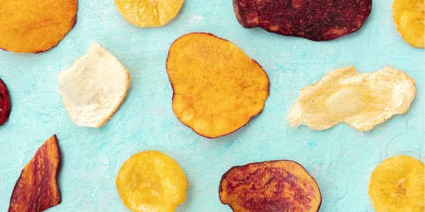 从上面拍摄的干果和蔬菜片的全景。健康的素食零食，一个有机食品平放在一个蓝色的背景图片下载