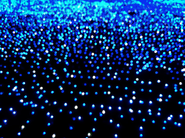 在黑暗中散焦的蓝色灯光的背景。散景效果图片下载