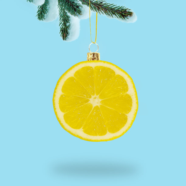 一片圣诞球形状的柠檬挂在树枝上。图片下载