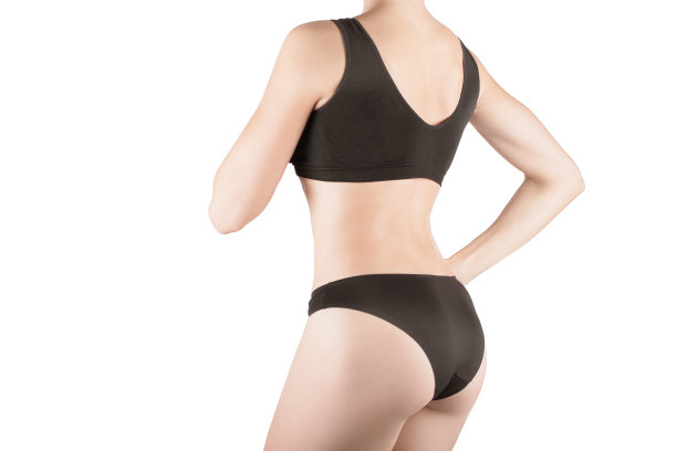 女性裁剪合身的背部和臀部在黑色内裤和顶部，孤立的白色。图片下载