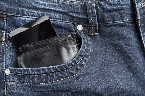 黑色皮革男性钱包和智能手机在牛仔裤口袋图片下载