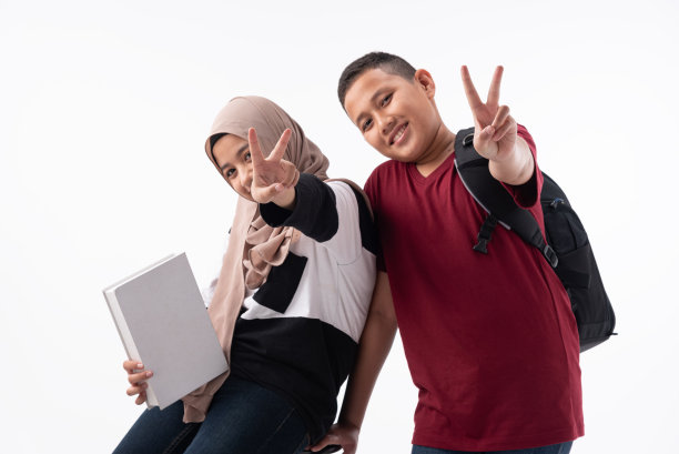 两位亚洲伊斯兰宗教少女站在白色的背景上捧着书，打算像书呆子一样读书。知识教育，努力学习，教育理念。图片下载