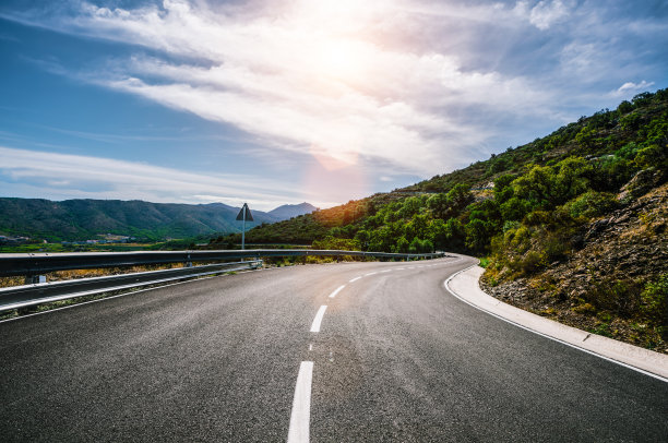 在一个阳光明媚的夏日，在明亮的夕阳下，空长的路图片下载