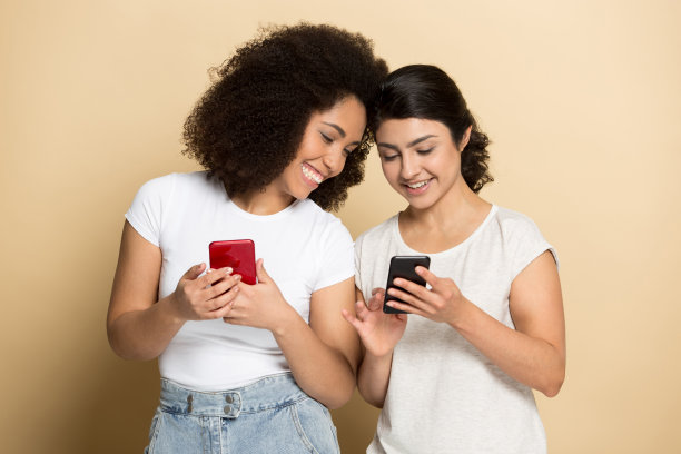 千禧一代的多民族女友们用手机笑图片下载