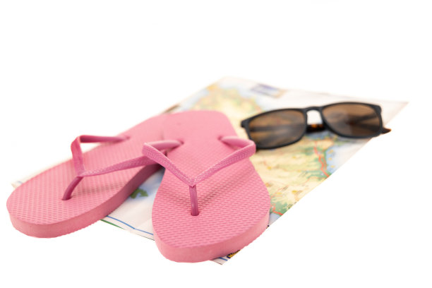 粉色人字拖和太阳镜放在地图上图片下载