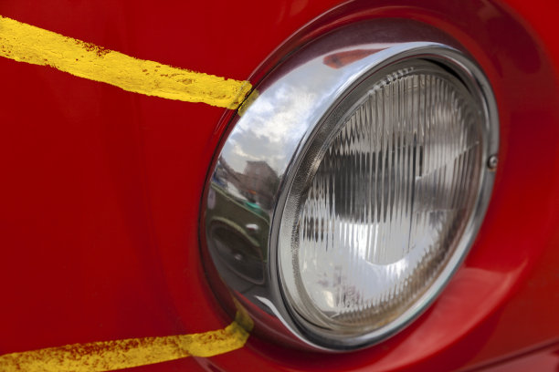 一辆带有黄色条纹的红色复古车的前灯图片下载