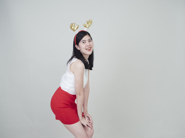 圣诞节的概念。戴着驯鹿头带的漂亮女人庆祝圣诞节图片下载