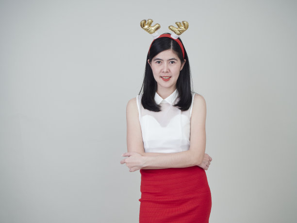 圣诞节的概念。戴着驯鹿头带的漂亮女人庆祝圣诞节图片下载