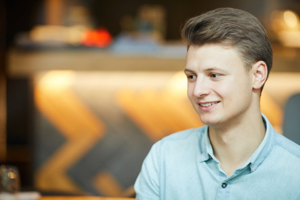 穿着衬衫的帅哥坐在酒吧的现代咖啡厅里，参与与朋友的交流图片下载