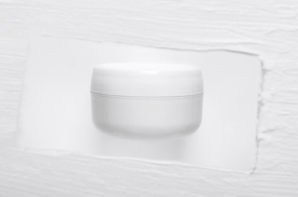 化妆品霜罐模型模糊的纹理背景。豪华化妆品容器隔离在奶油涂抹背景。散焦白色油漆笔触。面部护肤，面膜特写图片下载