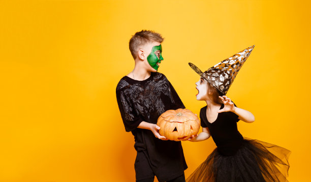 孩子们穿着万圣节服装玩南瓜图片下载
