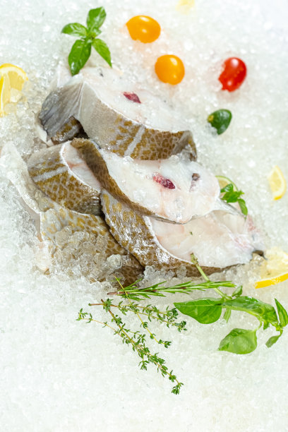 新鲜的海白鱼切片，躺在冰上，无头，樱桃，柠檬片和青柠片，切片，四周躺着，用绿色罗勒，轻，从上面侧看图片下载