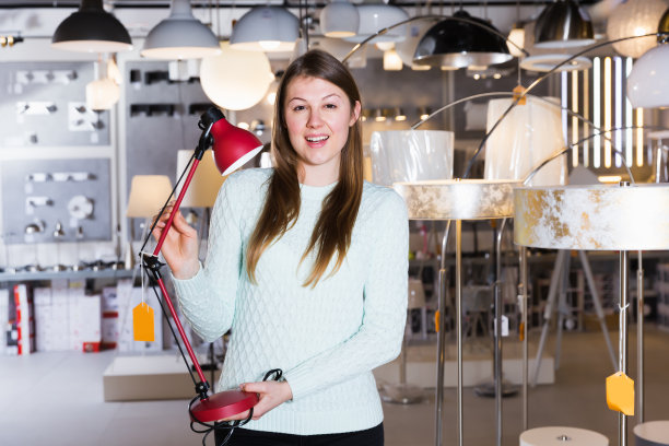 快乐的女人试着用台灯图片下载