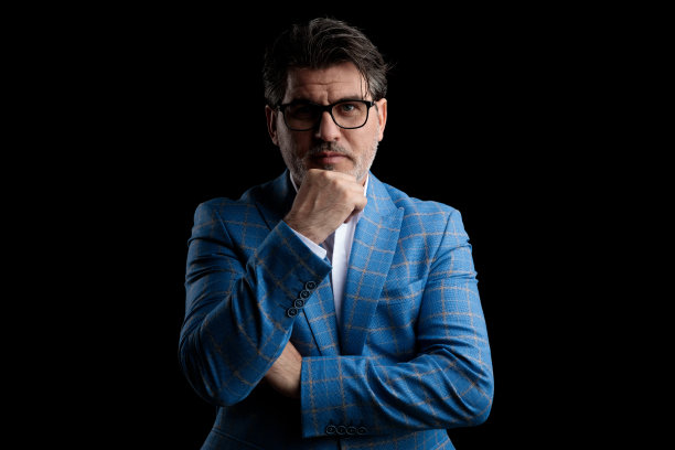 商人站着，下巴搁在拳头上，神情严肃图片下载