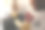 近距离观看一个女人坐在沙发上，手里拿着一杯茶读一本书。时髦的女孩穿着一件带有大红色亮片心形的羊毛衫。背景是圣诞树和点燃的蜡烛图片下载