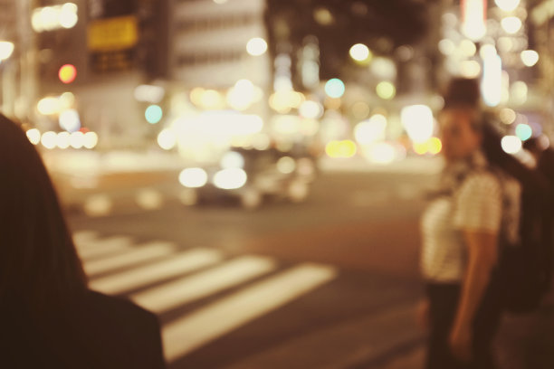 在日本拥挤的街道上，人们走在夜晚的步道上，模糊的背景用于背景。图片下载