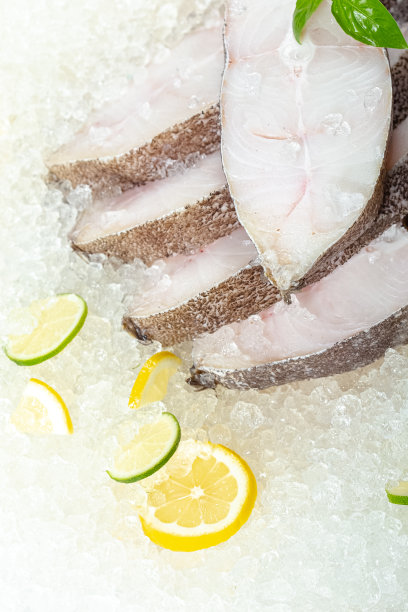 新鲜的海白鱼切片，躺在冰上，无头，樱桃，柠檬片和青柠片，切片，四周躺着，用绿色罗勒，轻，从上面侧看图片下载